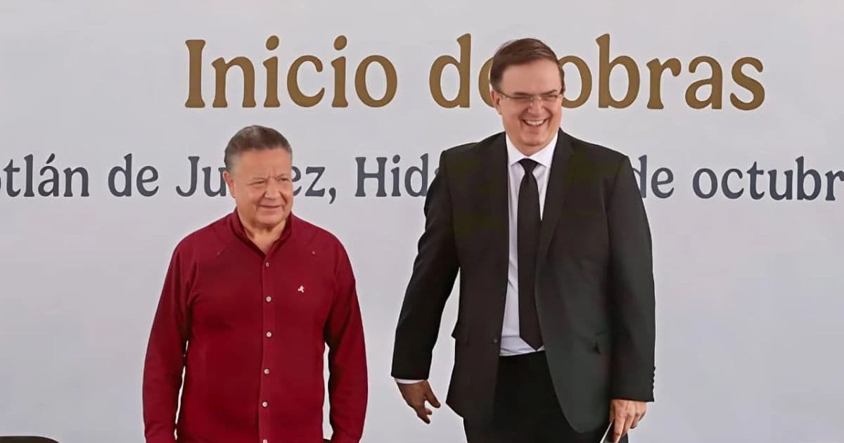 Julio Menchaca con camisa roja y Marcelo Ebrard con traje oscuro durante un evento de inicio de obras en Hidalgo