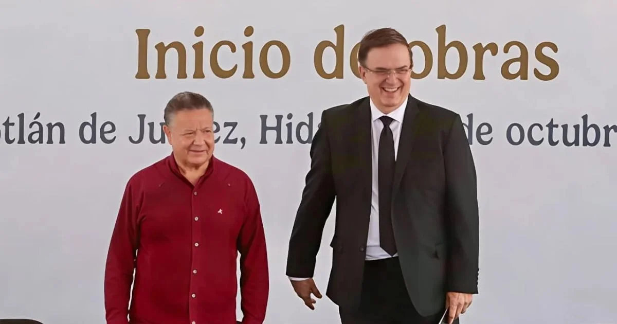 Julio Menchaca con camisa roja y Marcelo Ebrard con traje oscuro durante un evento de inicio de obras en Hidalgo