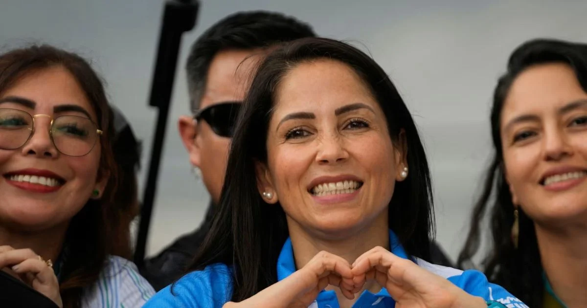 Luisa González sonríe ante la cámara junto a otras personas durante una aparición pública.