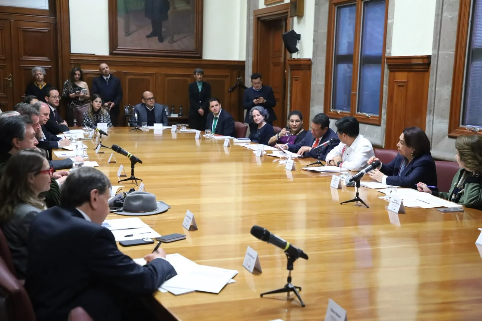 Reunión de representantes judiciales y empresariales alrededor de una mesa larga de trabajo.