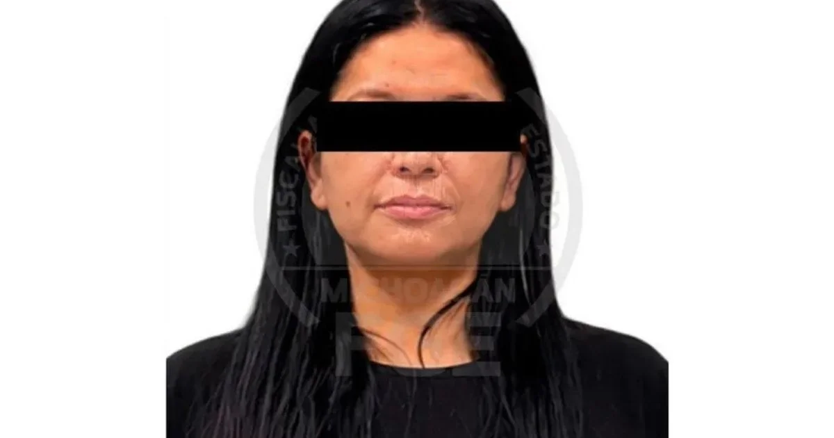 Retrato frontal de una mujer de cabello oscuro con franja negra sobre los ojos y marca institucional de la Fiscalía de Michoacán