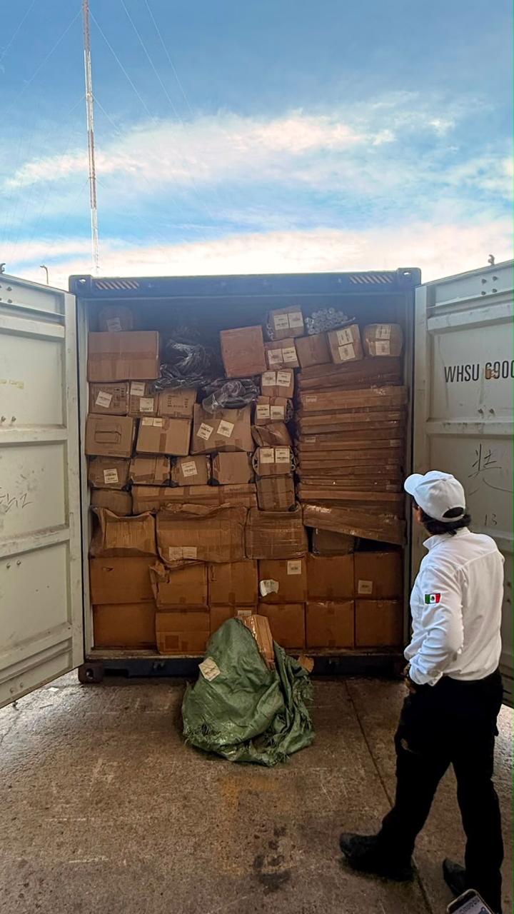 Aseguramiento de productos pirata en la Aduana de Lázaro Cárdenas durante operativo del IMPI y la ANAM. Contenedor abierto con cajas de mercancía.