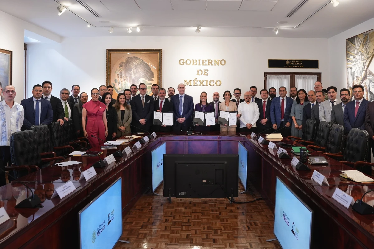 Representantes del gobierno y del sector gasolinero reunidos en una sala oficial, con tres personas al centro mostrando documentos que representan el precio de la Gasolina Magna.