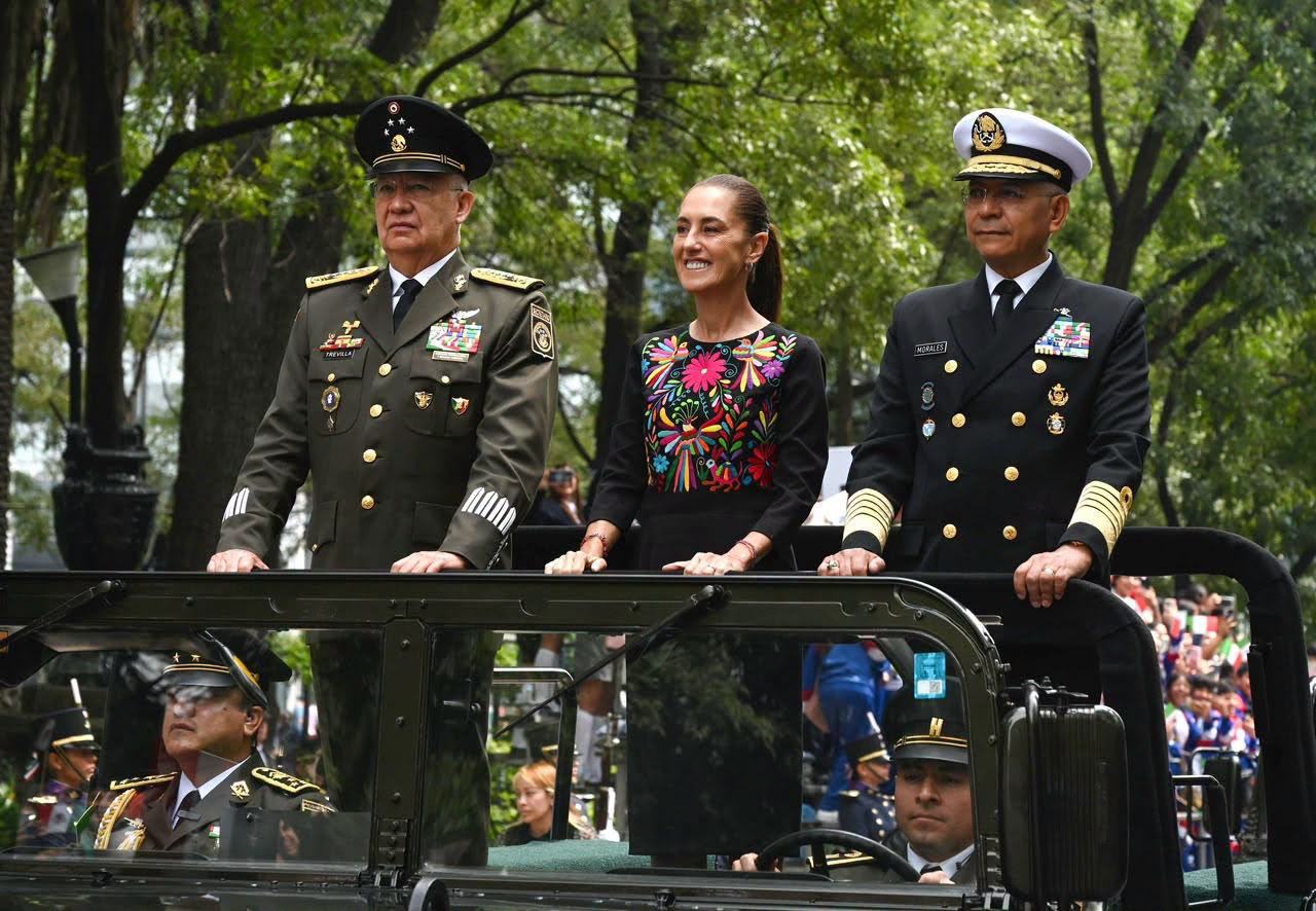Ceremonia cívico-militar sobre soberanía nacional con una mujer acompañada por dos mandos de las Fuerzas Armadas