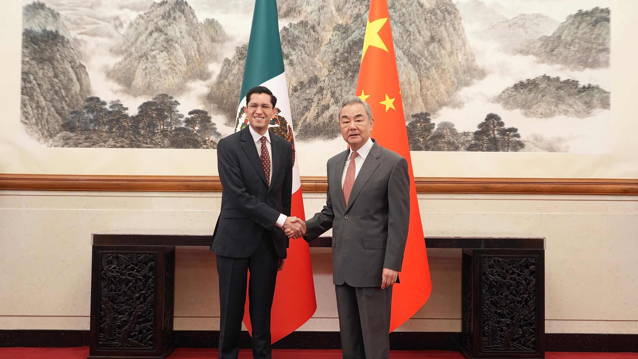 Roberto Velasco y Wang Yi estrechan la mano ante las banderas de México y China