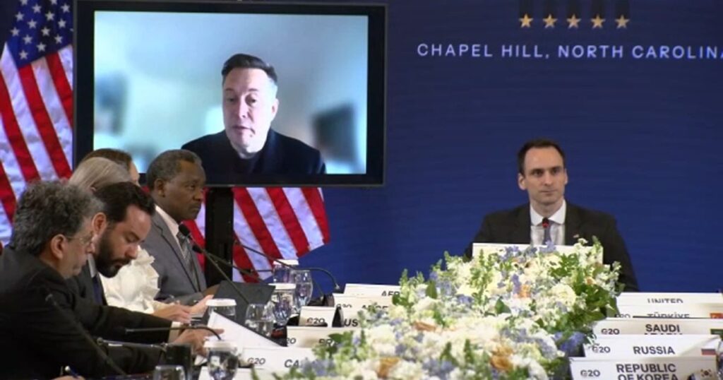 Elon Musk interviniendo virtualmente en el G20 Innovation Ministerial desde una pantalla durante su participación en Chapel Hill