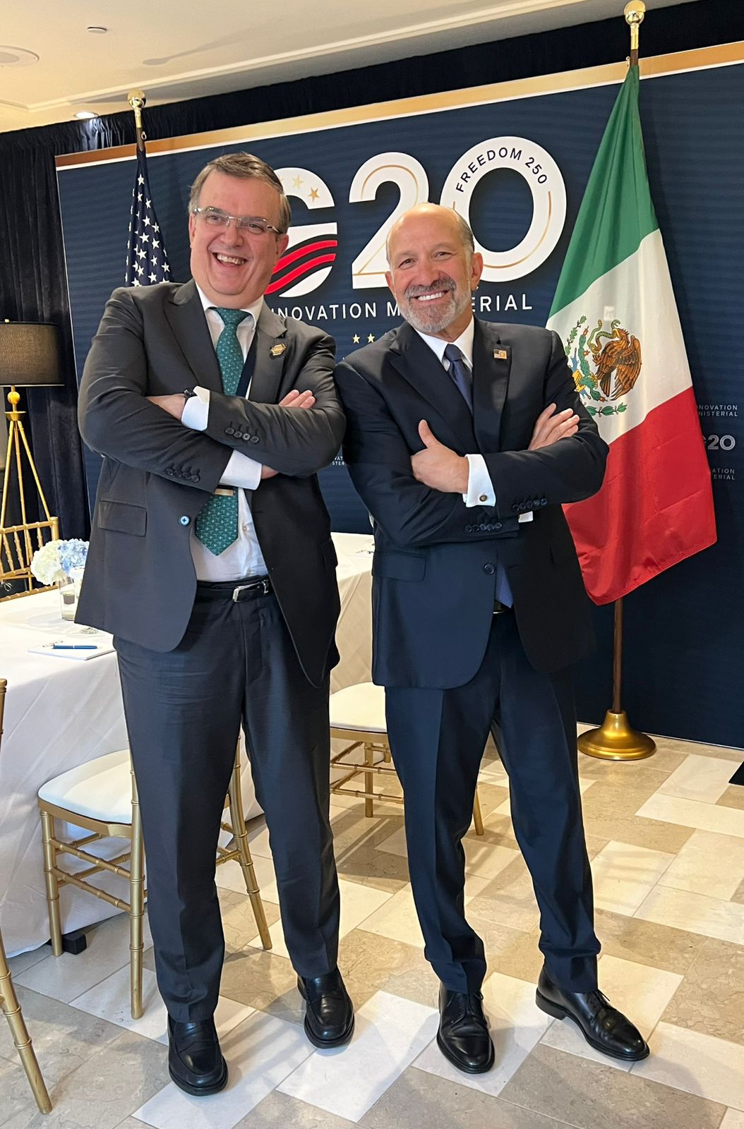 Marcelo Ebrard y Howard Lutnick posan frente a las banderas de México y Estados Unidos durante la reunión de Ministros de Innovación del G20