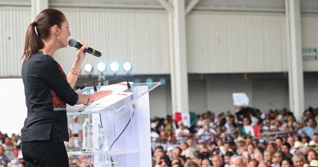 Sheinbaum habla con un micrófono sobre Hospitales en Guanajuato desde un podio ante asistentes a un evento público