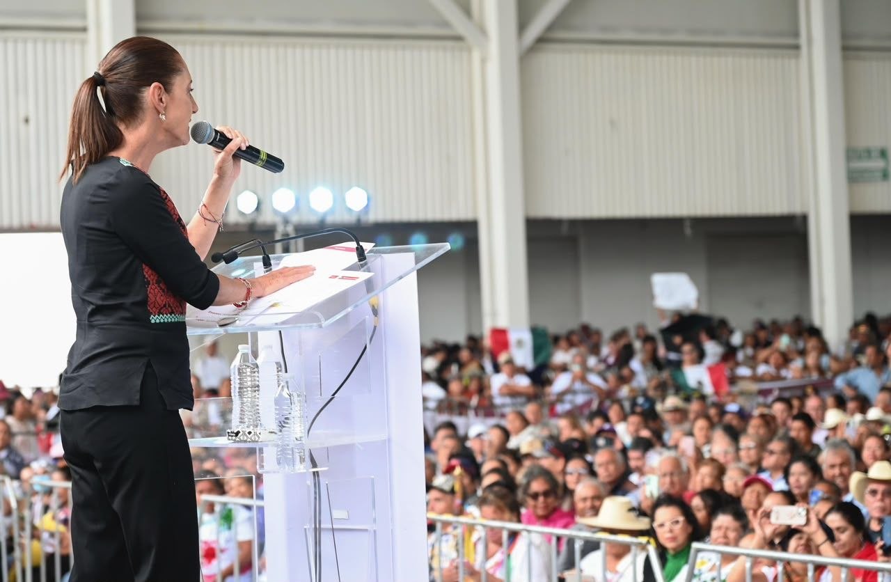 Hospitales en Guanajuato: Cladia Sheinbaum habla con un micrófono desde un podio ante asistentes a un evento público