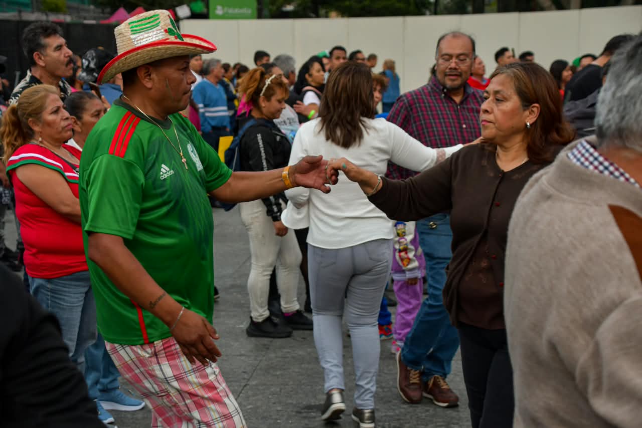 Asistentes bailan durante la verbena popular del 15 de septiembre en Iztapalapa