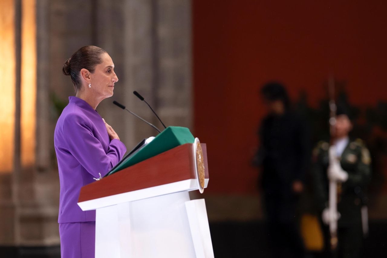 La Presidenta Claudia Sheinbaum con la mano en el pecho durante el Himno Nacional en un acto solemne