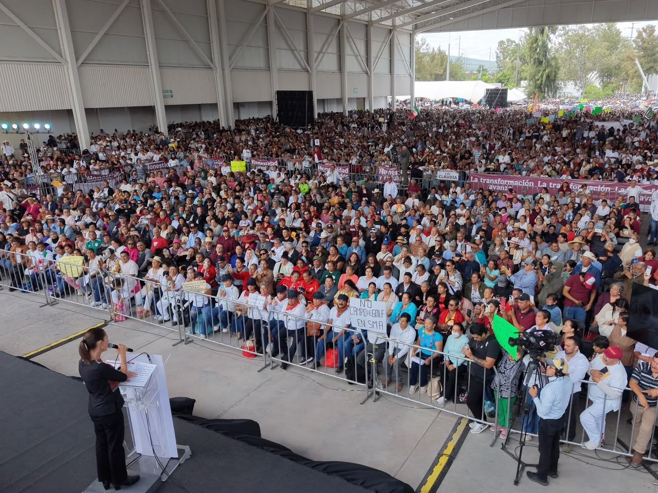 Vista amplia de asistentes reunidos en un evento público dentro de un recinto sobre agua para León