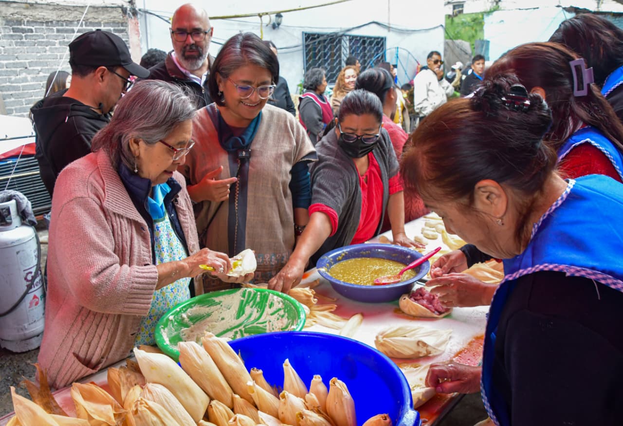 Integrantes de una comunidad preparan alimentos tradicionales alrededor de una mesa