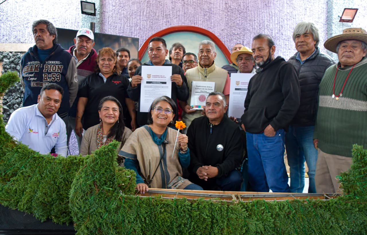 Grupo de participantes posa con documentos durante una celebración comunitaria en Iztapalapa