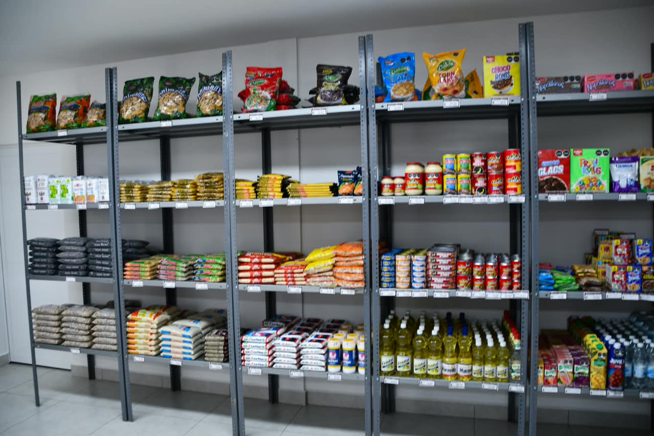 Estantes con alimentos y productos de abasto exhibidos dentro de una Tienda Bienestar