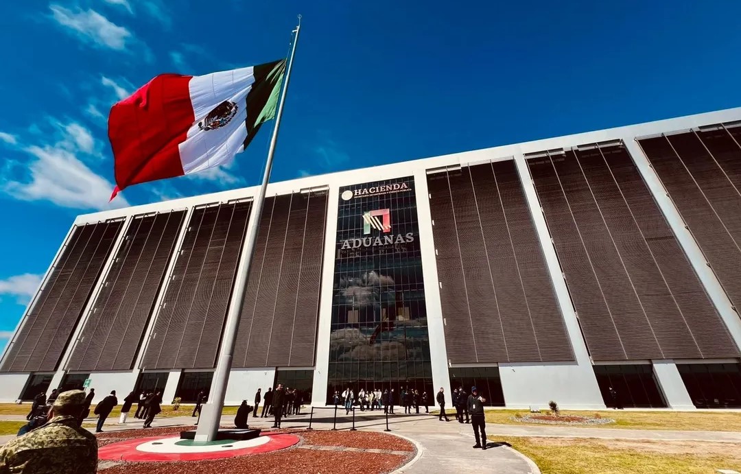 Bandera de México frente al edificio de la Agencia Nacional de Aduanas de México