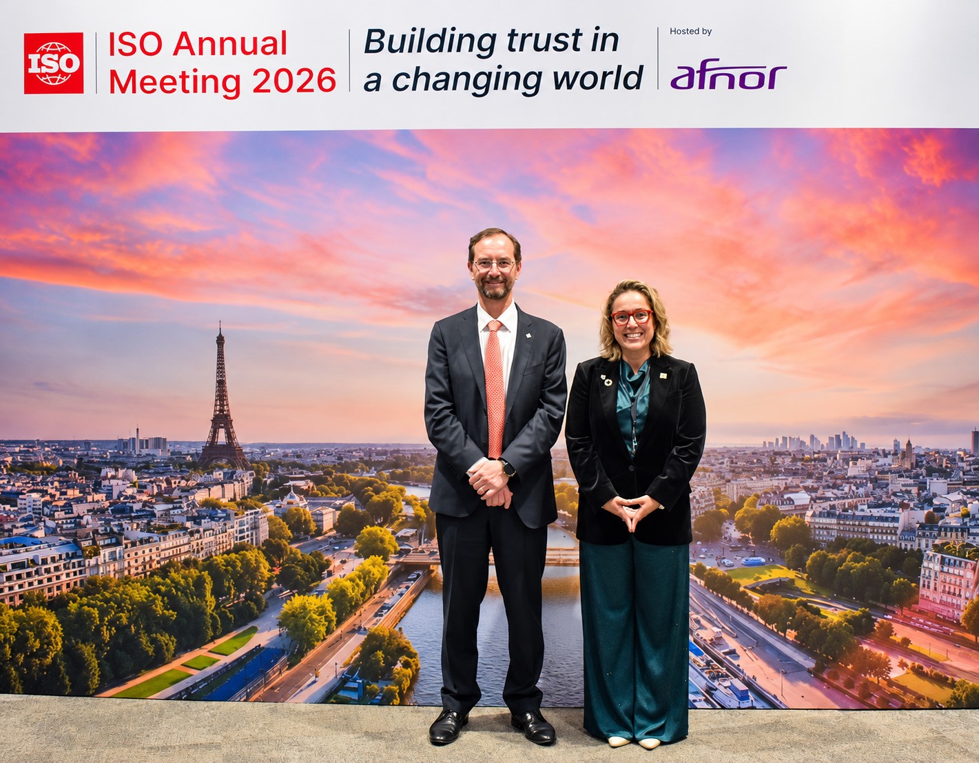 Representantes posan frente a la imagen oficial de la Reunión Anual ISO 2026 en París sobre normalización internacional
