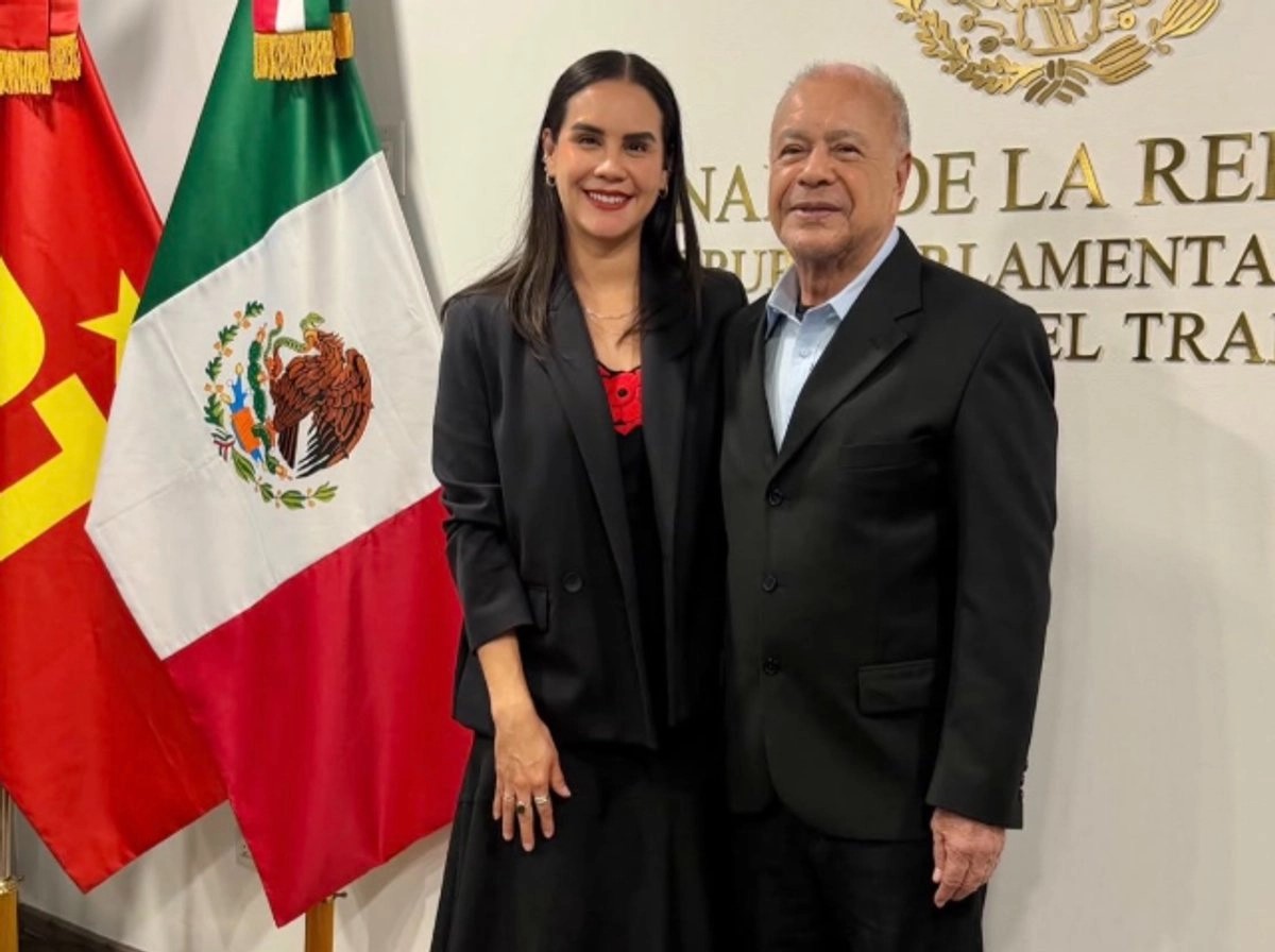 Rosi Bayardo y Alberto Anaya posan juntos frente a las banderas de México y del Partido del Trabajo en el Senado.
