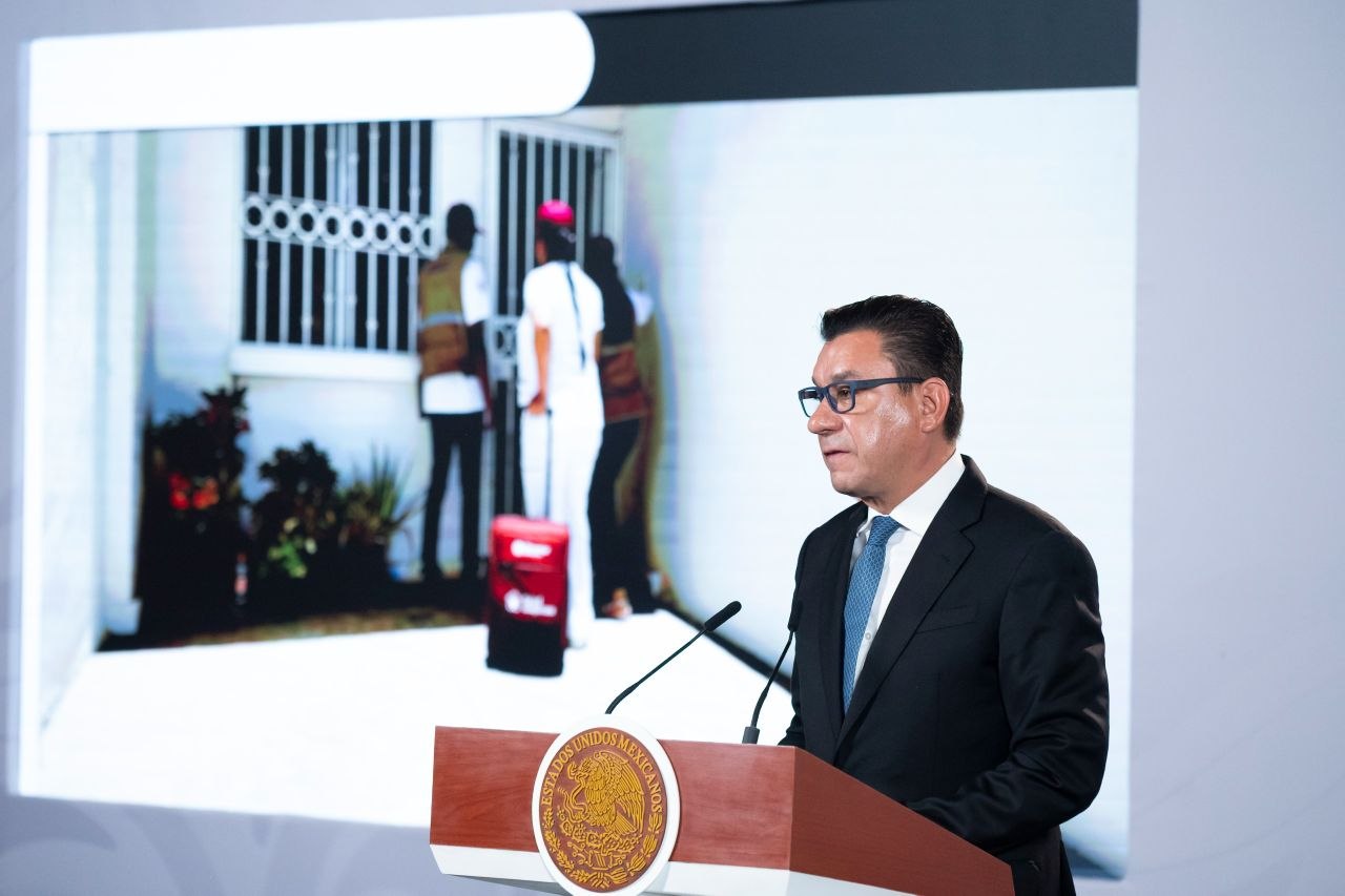 Funcionario federal habla desde un podio durante una presentación sobre visitas domiciliarias de salud