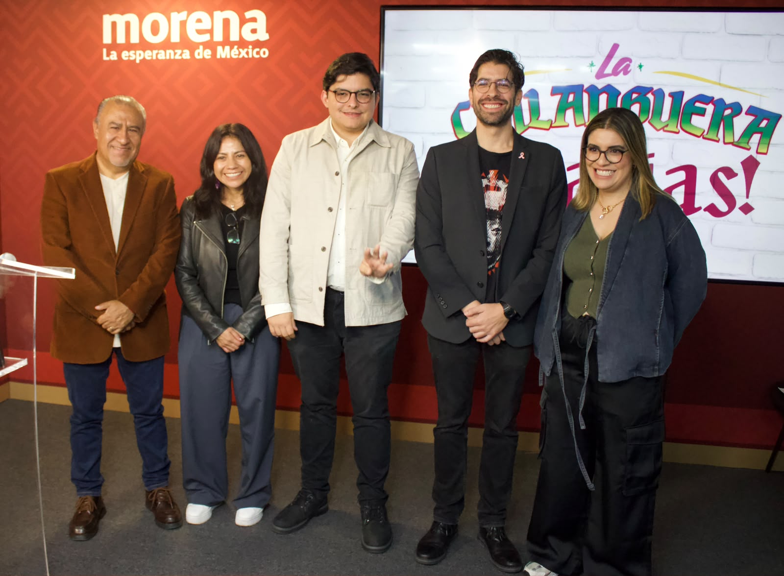 Cinco participantes posan frente a un fondo con los emblemas de Morena y La Chilanguera