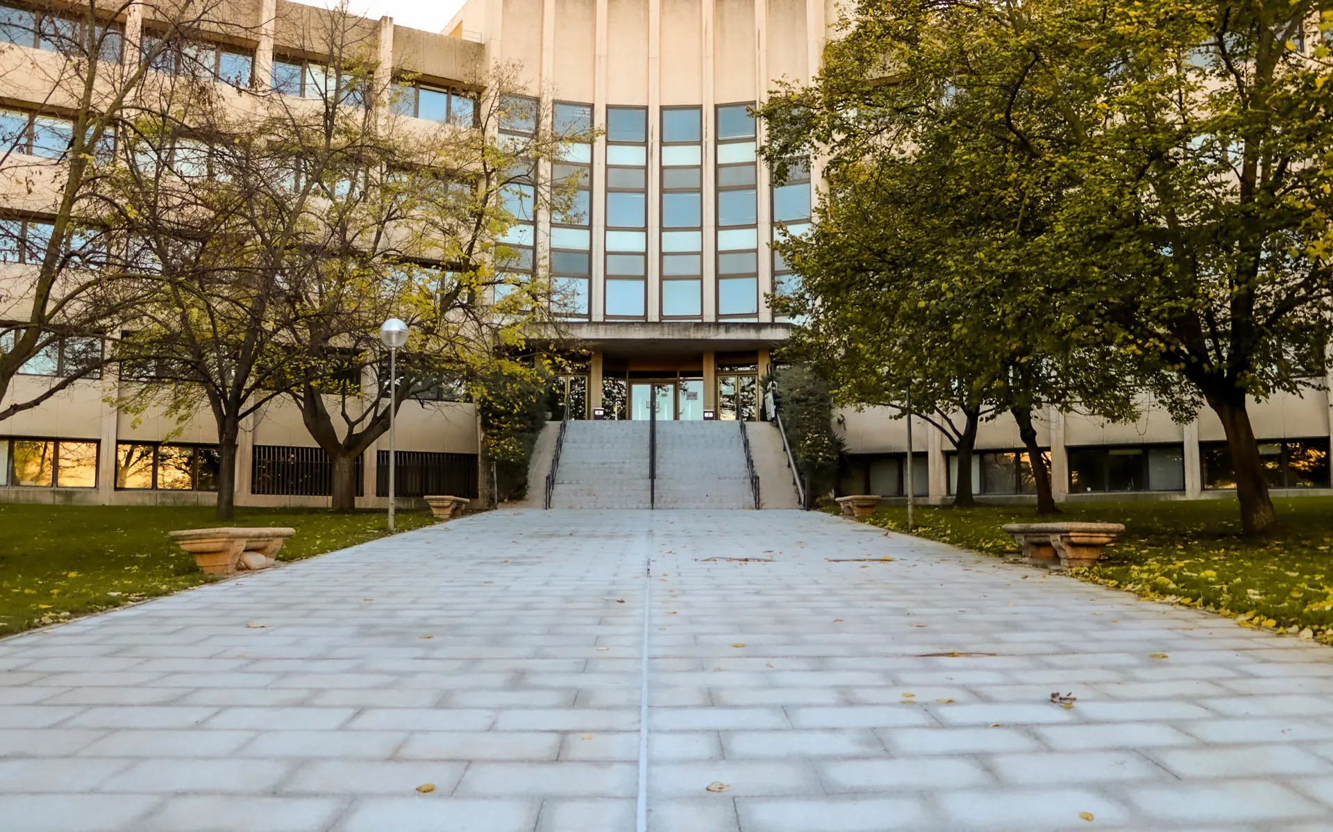 Fachada de un edificio institucional rodeado de árboles