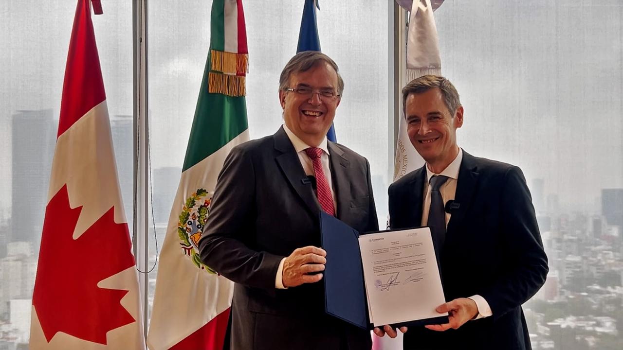 Representantes posan con documento durante reunión sobre dirigibles de carga entre México y Flying Whales