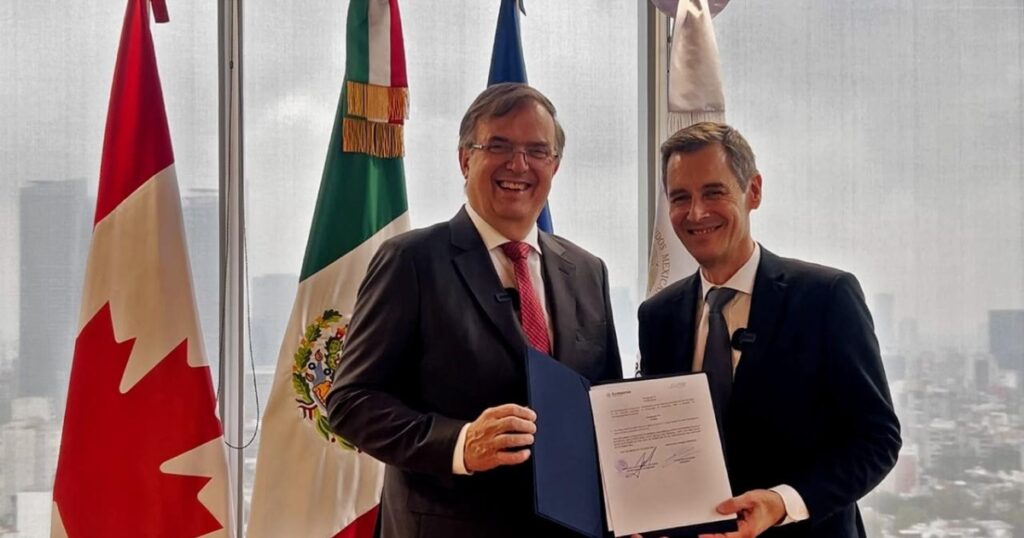 Dos representantes sostienen un documento durante reunión sobre logística aérea en México