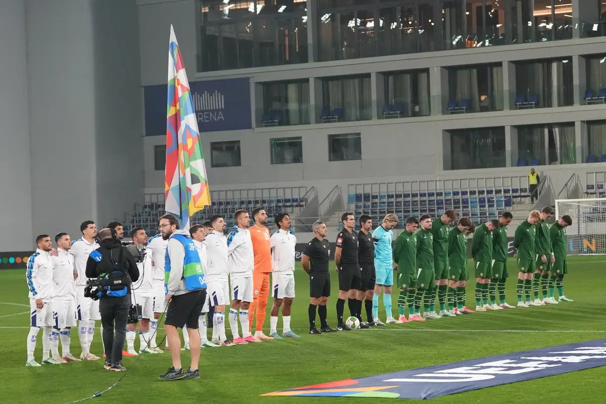 Dos selecciones de futbol y el equipo arbitral permanecen formados sobre el campo antes de un partido