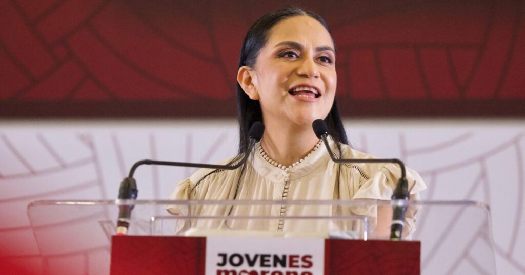 Oradora frente a micrófonos y podio de Jóvenes Morena en un encuentro partidista.