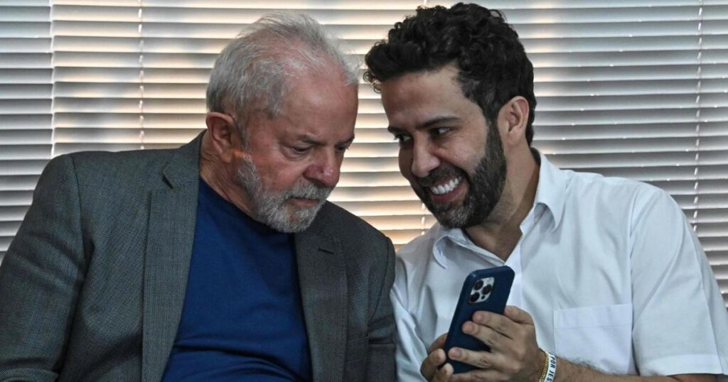 Luiz Inácio Lula da Silva y André Janones observan juntos un teléfono móvil en una reunión