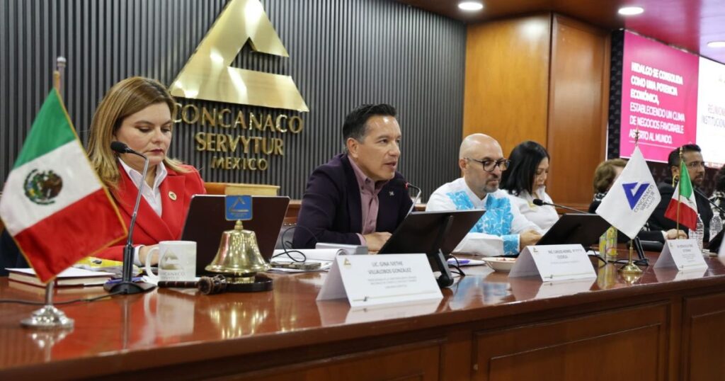 Funcionarios y representantes de Concanaco Servytur reunidos en una mesa de trabajo; al fondo se observa el emblema de la confederación.