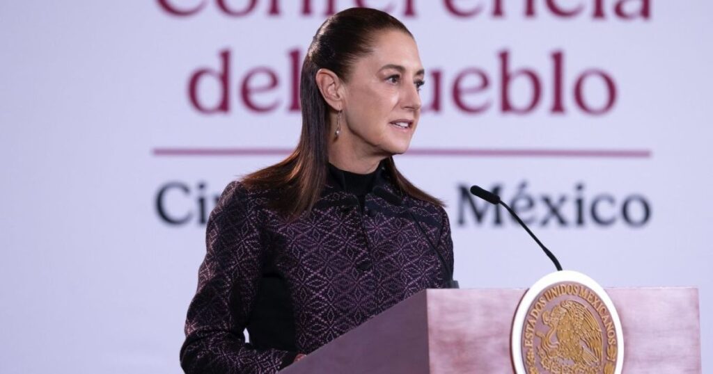 Mujer habla desde un podio oficial con el Escudo Nacional durante una conferencia