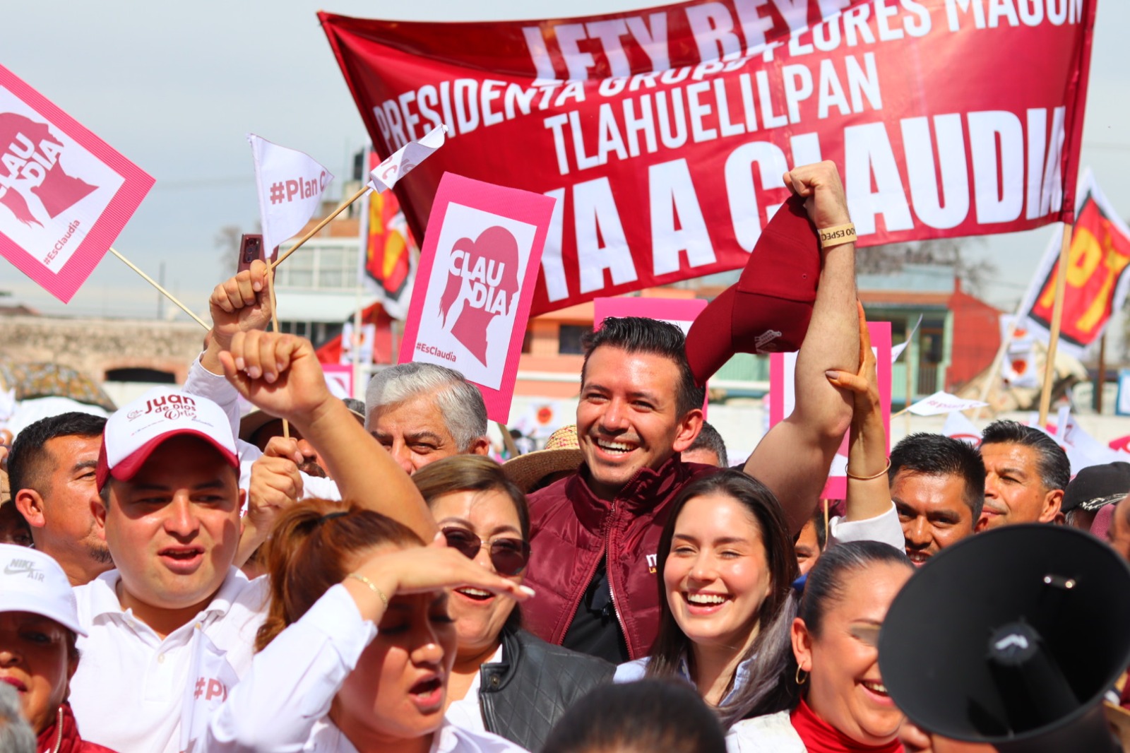 Concentración política con simpatizantes que levantan banderas y carteles