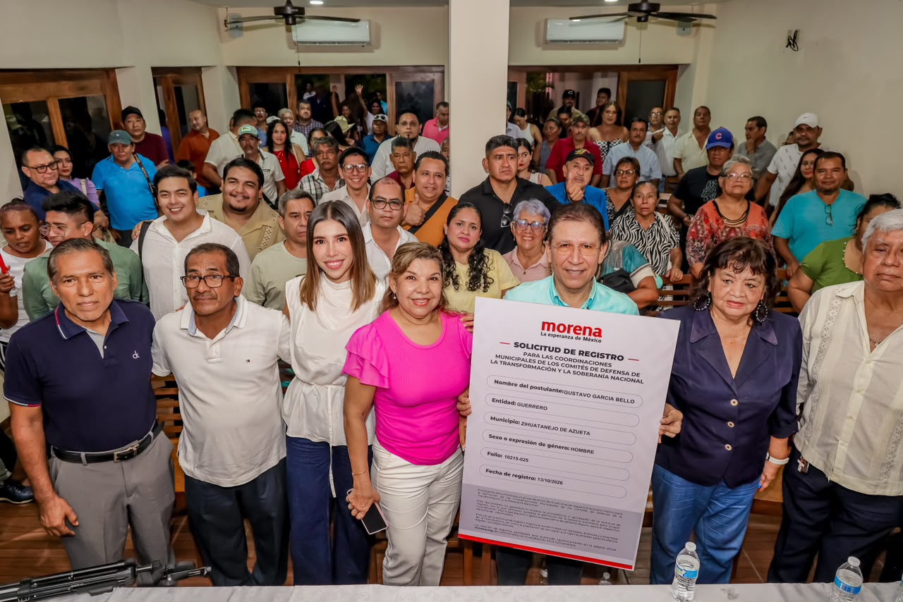 Grupo de personas posa con una solicitud de registro de Morena a nombre de Gustavo García Bello.